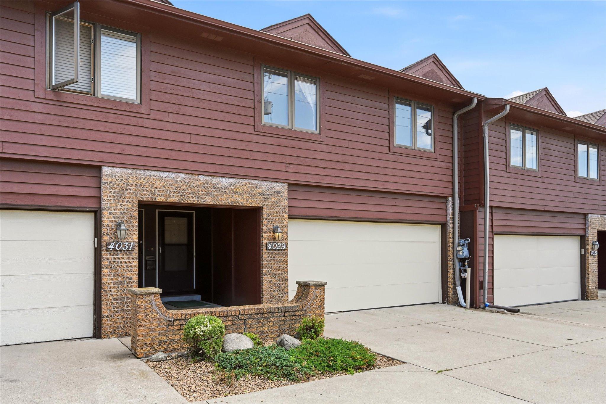 The two-car garage includes built-in shelving for added organization.