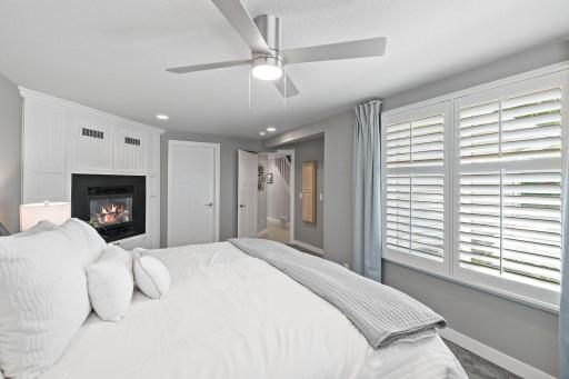 A serene primary suite with its own fireplace and plantation shutters — a private retreat to unwind at the end of the day