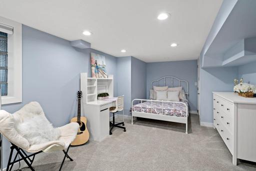 A charming lower-level bedroom with plenty of natural light and space to study, create, or relax