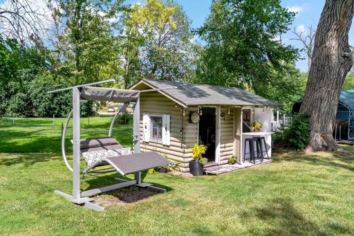 A charming "she shed" with its own bar seating and string lights — a fun bonus space tucked among the trees
