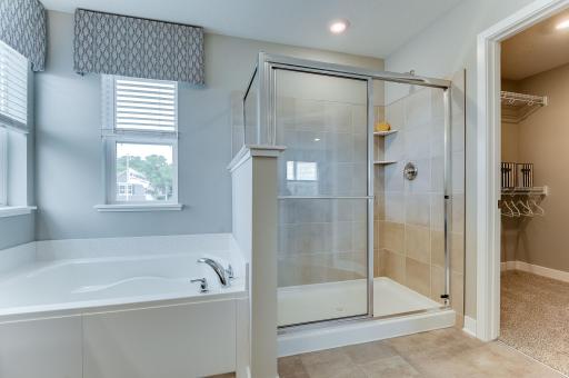 Here you can see the shower with a tile surround and built-in shelves. The second walk-in closet allows plenty of space for your wardrobe and accessories. Photo of the model home, finishes may vary.