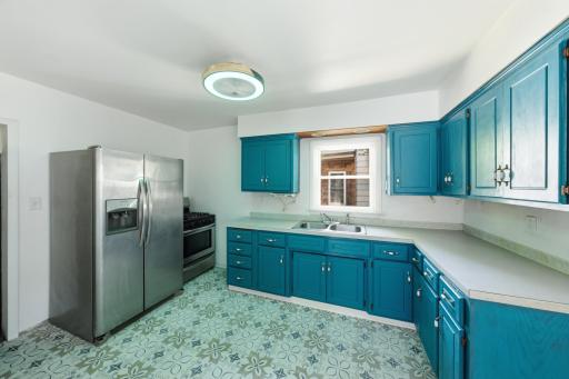 Updated kitchen with stainless steel appliances, freshly painted cabinets, new vinyl flooring, and a dimmable air flow color changing remote control ceiling fan!