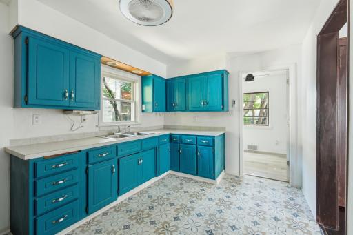 Freshly painted custom color cabinets with recessed lighting over the sink, new dimmable air flow color changing remote control ceiling fan, and new vinyl flooring!
