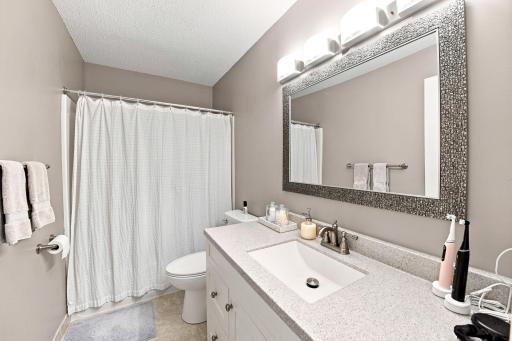 Full bath with ample countertop space, vanity storage, and modern fixtures.