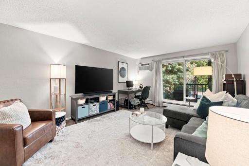 Bright, open living room with sliding glass door walkout to the private deck.