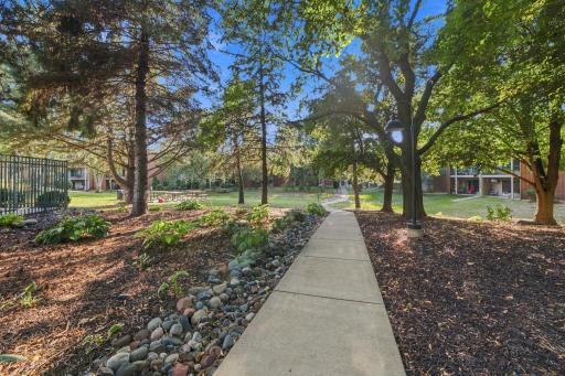 Paved walking path shaded by mature trees throughout the property grounds.