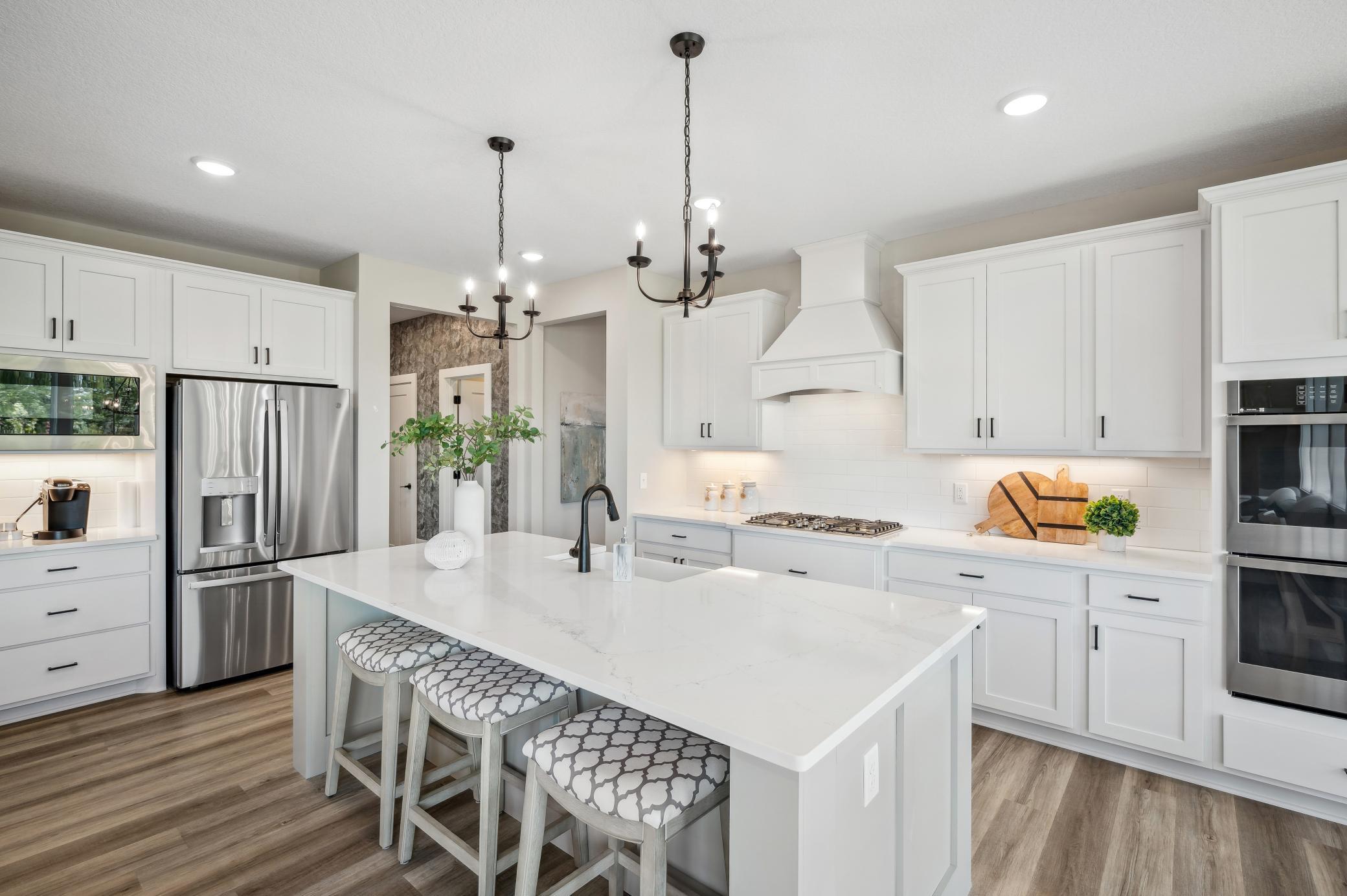 Photo is of former model home. This home will have many similar options and upgrades. Actual Kitchen will have stained island cabinets, stained hood, and white perimeter cabinets.