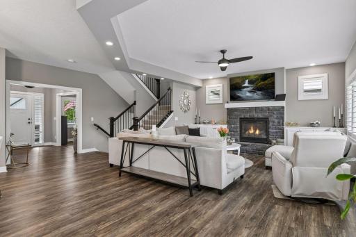 Another view of the living room showcases the gorgeous stone-surround gas fireplace and the open flow of the main level.