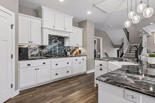 The large gas range and statement vent hood create the perfect setup for anyone who loves to cook.