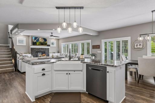 A view from the center island showcases the beautiful farmhouse sink and open sightlines into the living room.