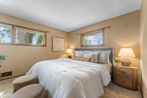 The primary bedroom has windows on two sides with the larger ones looking out to the backyard.