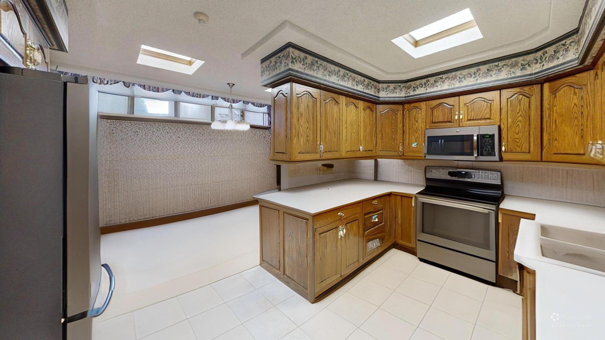 Kitchen and adjoining dining area shown with furnishings digitally removed to highlight the flow between spaces