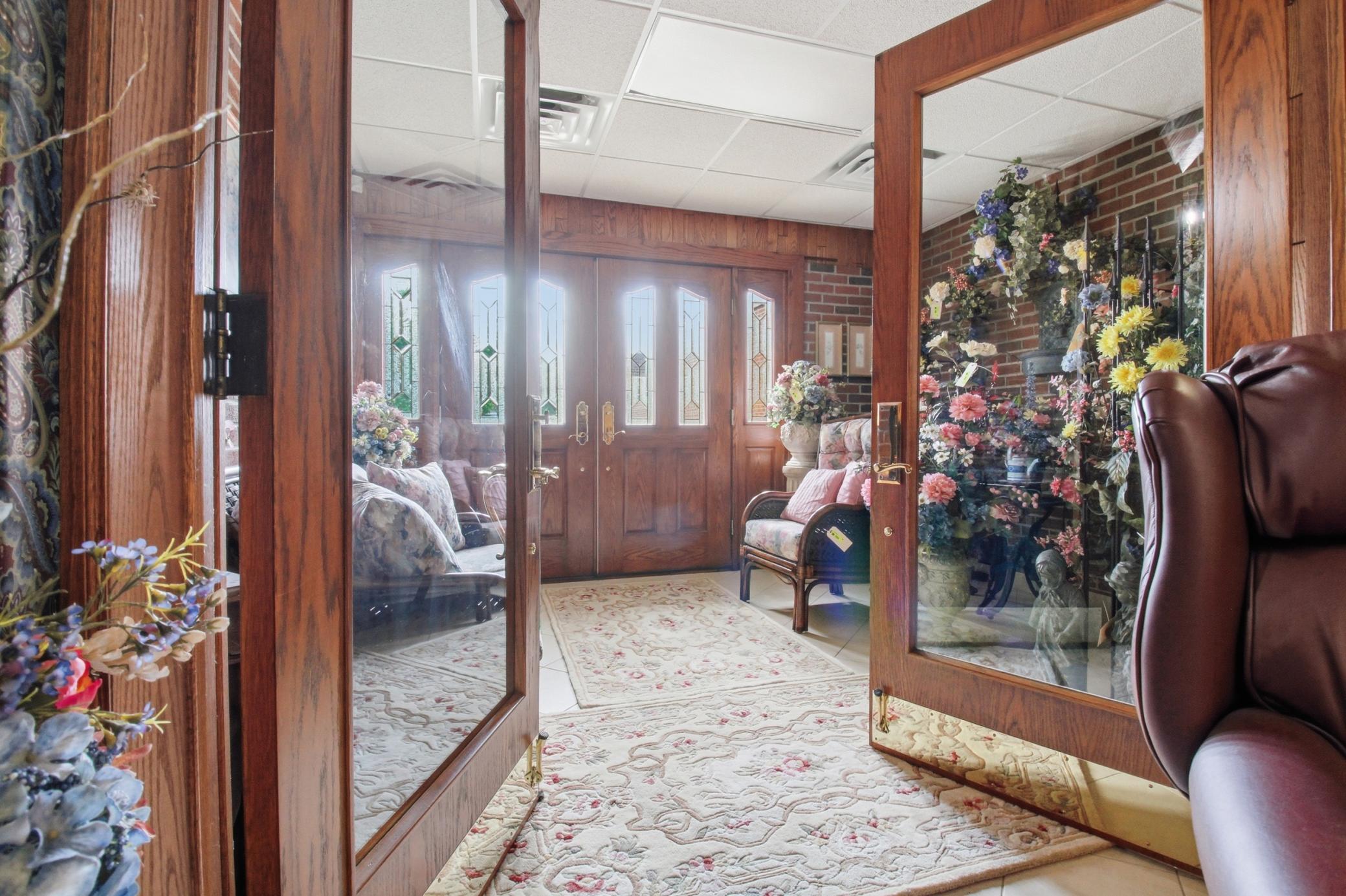 Grand main entrance showcasing custom oak woodwork, stained glass accents, and abundant natural light