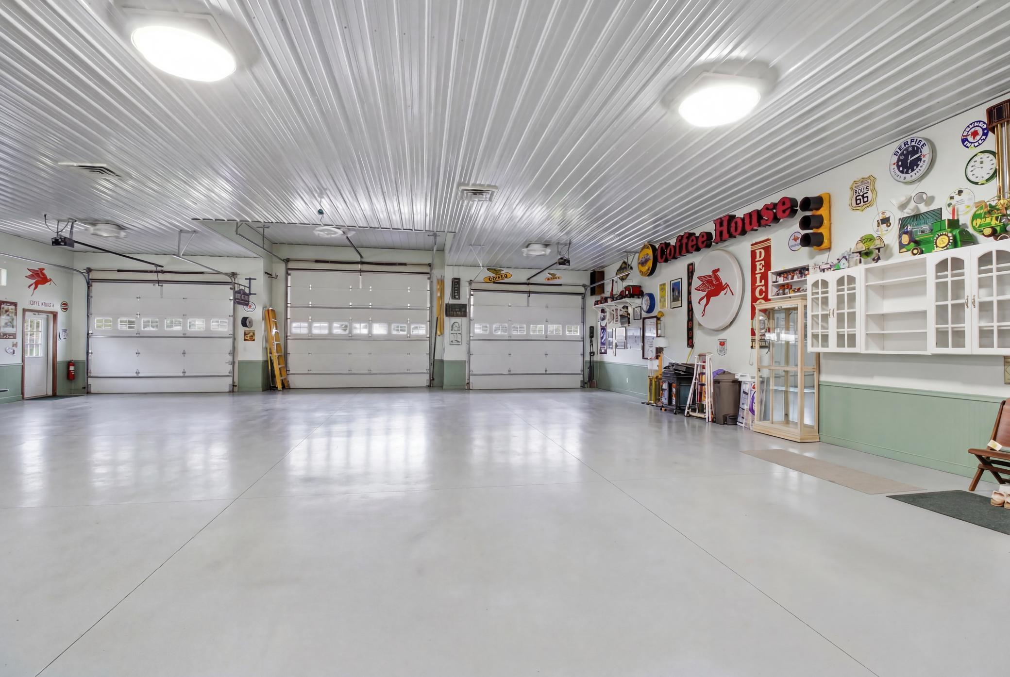 Climate-controlled finished garage/flex space with 3 overhead doors and polished floor