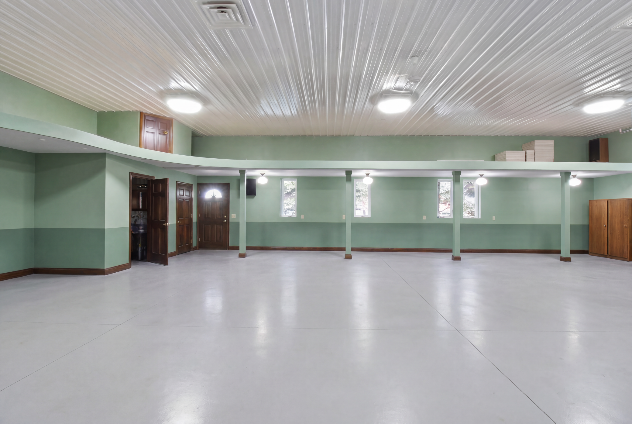 Climate-controlled finished garage/flex space with 3 overhead doors and polished floor