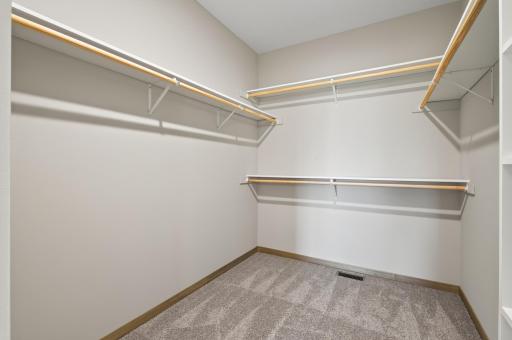 Very nice sized walk in closet off the primary bathroom. Note the double rod/shelfed on the end for shirt and pants hanging.