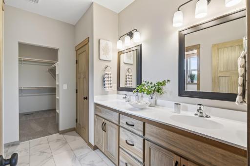 The primary bathroom offers a large double sink vanity, linen closet and LVT flooring.