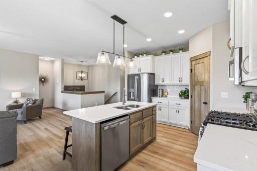Center island with snack bar overhang and solid surface countertop with undermount sink.
