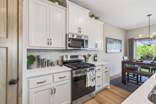 42 inch upper cabinets, built in garbage and recycling center, ceramic tiled backsplash and solid surface countertops.