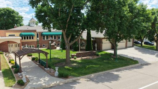 Distinctive brick property with cupola detail, landscaped grounds, expansive driveway, and multiple garage bays