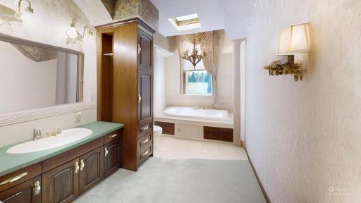 Spacious bath with soaking tub, skylight, built-in storage, and natural light