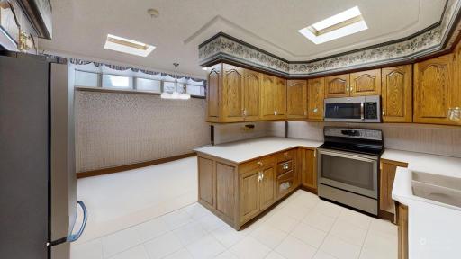 Kitchen and adjoining dining area shown with furnishings digitally removed to highlight the flow between spaces