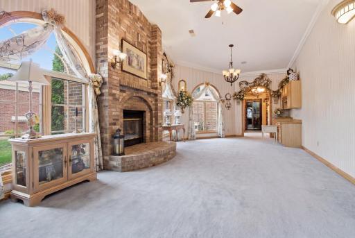 Dramatic space with arched windows, fireplace, and abundant natural light.