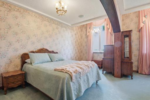 Spacious bedroom with arched woodwork, distinctive character details, and flexible layout potential