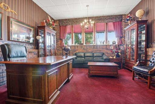Elegant flex space featuring custom woodwork, expansive windows, and chandelier lighting.