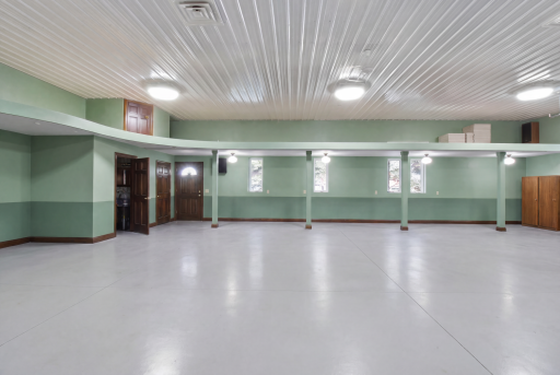Climate-controlled finished garage/flex space with 3 overhead doors and polished floor