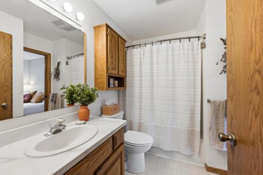 Main Level full bath offers walk through access to the Primary Bedroom.