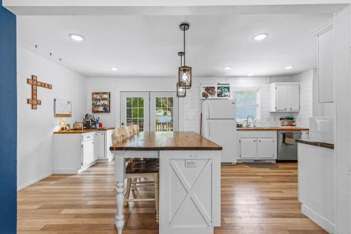 Stunning wood countertops and tabletops warmly compliment the white, bright space