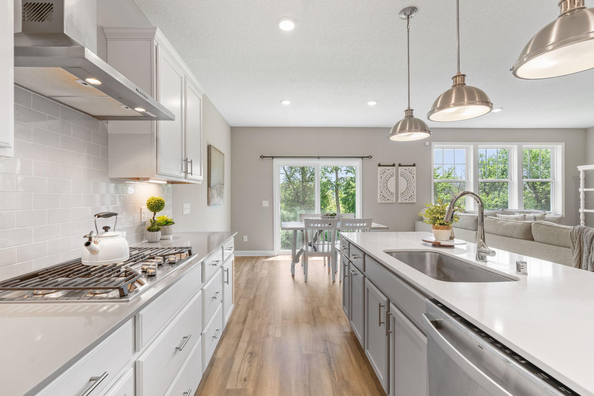 Gourmet Kitchen w/ quartz counters, oversized island, SS apps (inc gas cooktop) & walk-in pantry