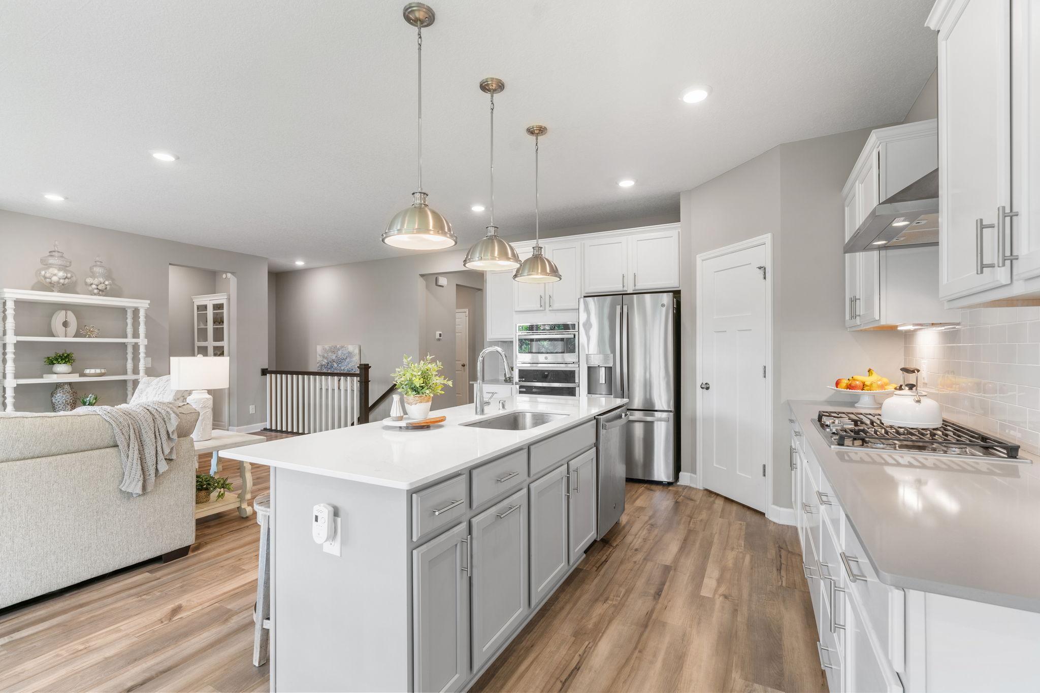 Gourmet Kitchen w/ quartz counters, oversized island, SS apps (inc gas cooktop) & walk-in pantry