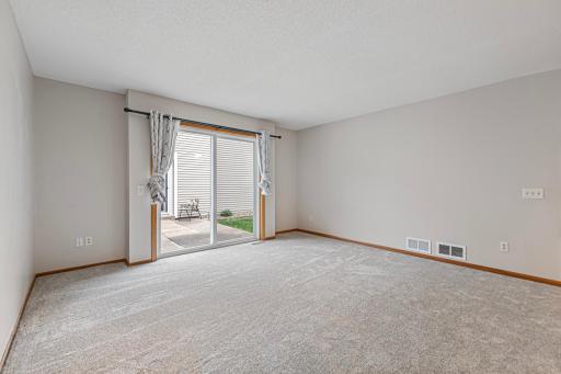 Living room with new carpeting and sliding door to the patio