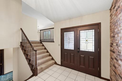 Welcoming foyer with tile floors! One wall with real brick! Original double front doors!
