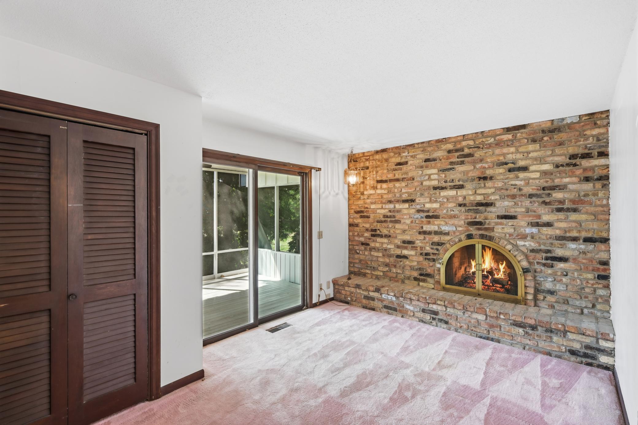 Entire brick wall has a stylish fireplace! Adjacent to your screened in porch!