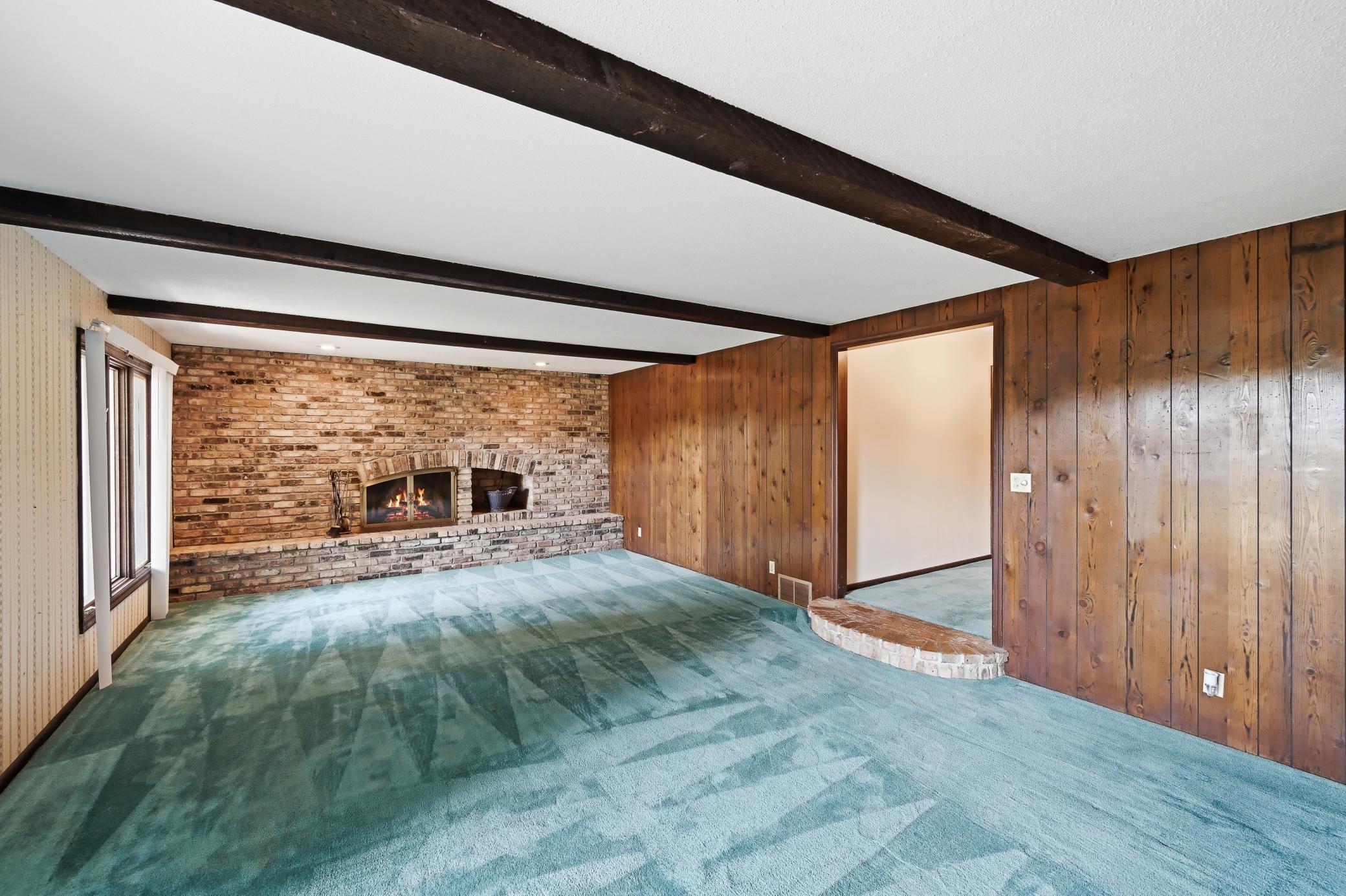 Finished lower level has a spacious step down family room with another brick fireplace.
