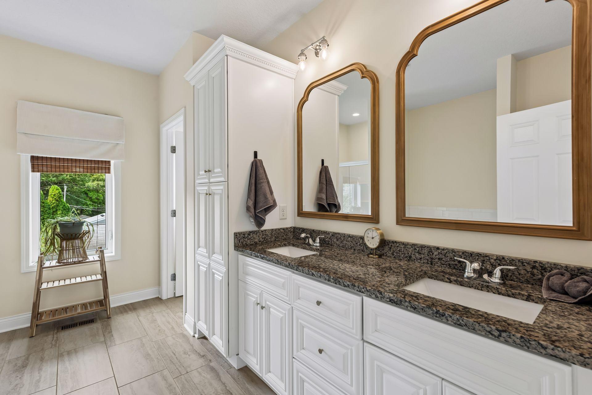 The luxurious primary bath features dual granite vanities, custom cabinetry, tile flooring, and plenty of storage, creating a spa-inspired space to begin and end each day.