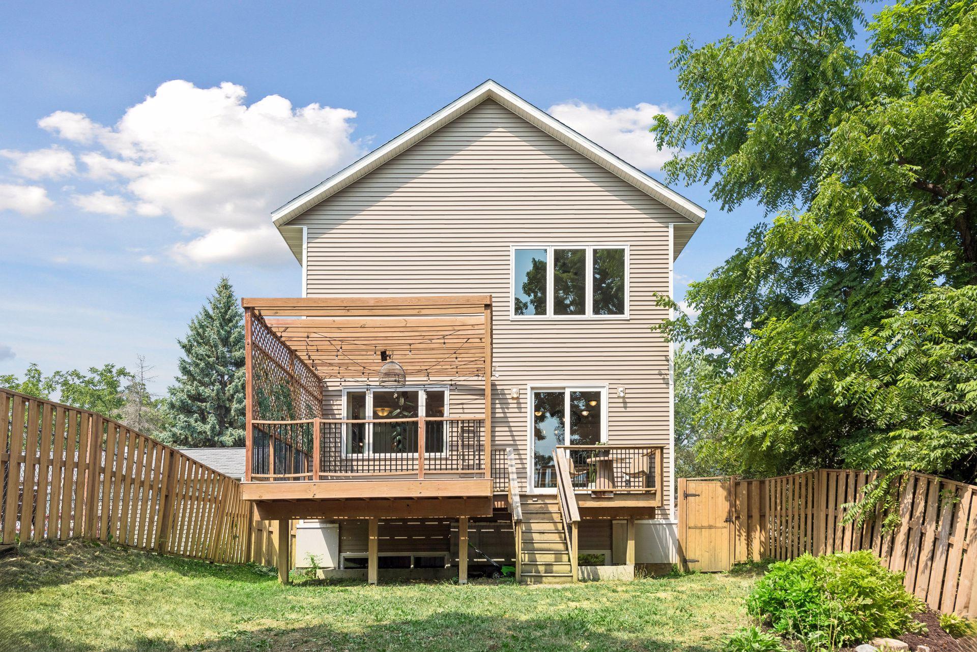 The backyard is complemented by an impressive rear elevation featuring a large deck, pergola, and easy access to both indoor and outdoor living spaces.