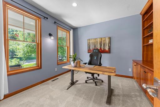The dedicated home office/den includes large windows, recessed lights, and brand-new carpet.