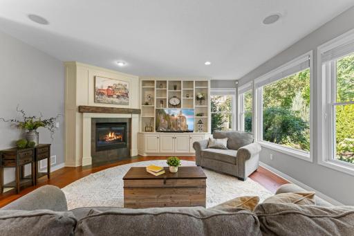 The living room features a wall of Andersen windows overlooking the private backyard.