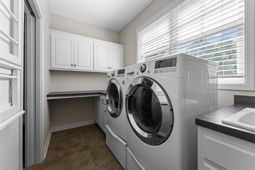 The laundry room includes built-in cabinets and a folding counter.