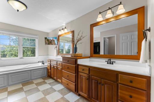 The private full primary bathroom includes beautiful cherry cabinetry with dual comfort-height sinks and lots of storage, ceramic tile floors and a large window for natural light.