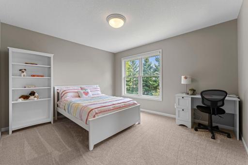 The third of the four bedrooms includes a walk-in closet and a large window, and is connected to the full Jack & Jill bathroom