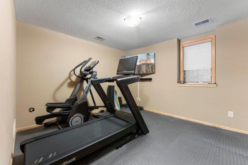 The fifth bedroom includes an egress window and a large closet, and it is currently being used as a workout room with gym-mat flooring.