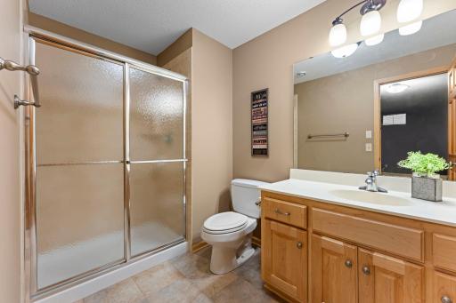 The lower-level 3/4 bathroom includes ceramic tile floors and a large vanity with storage.
