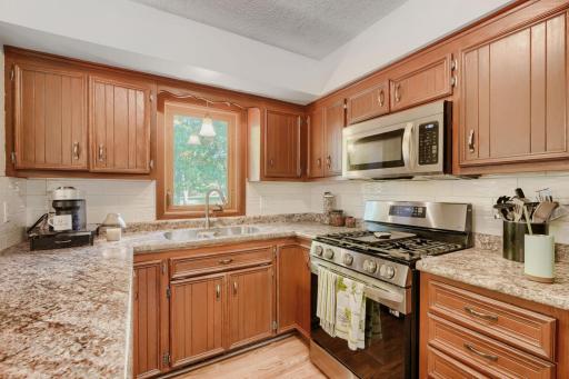 Kitchen has a gas range and stainless steel appliances