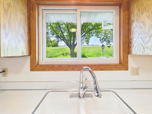 Take in the peaceful, park-like view of open green space and mature trees right outside your kitchen window.