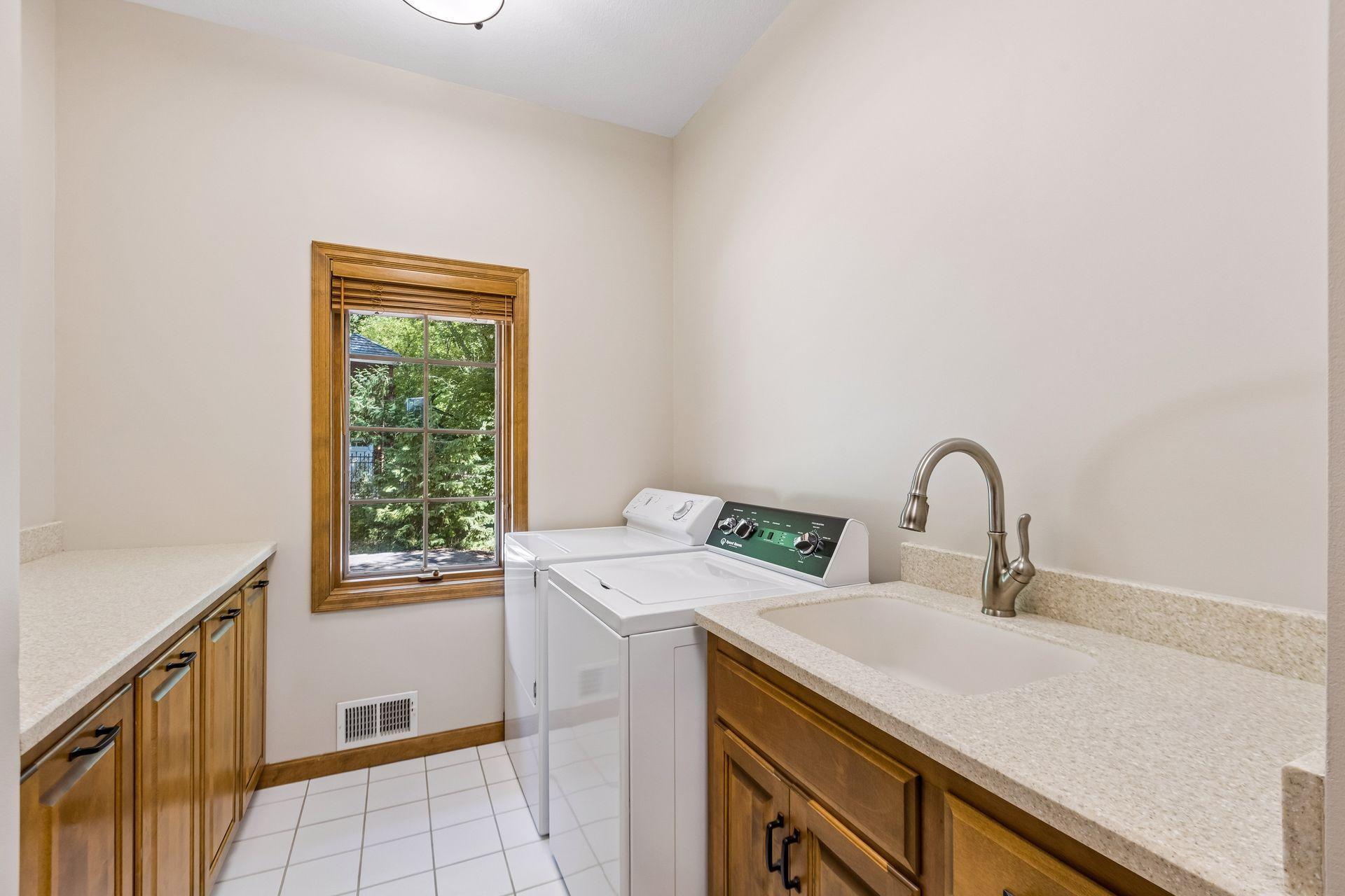 Main-level laundry room with a sink and built-in storage located next to the mudroom.